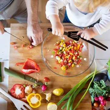 adult and child cooking next to each other
